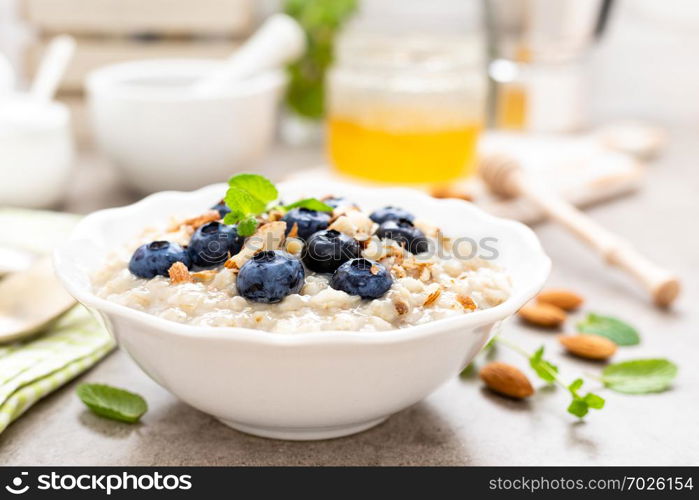 Oatmeal with fresh blueberry, almond nuts and honey for breakfast