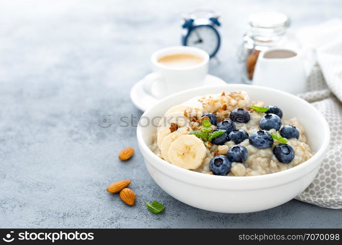 Oatmeal with fresh blueberry, banana, almond nuts and honey for breakfast