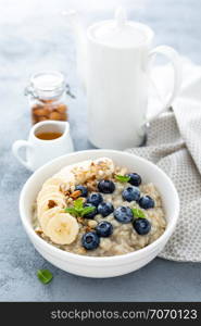 Oatmeal with fresh blueberry, banana, almond nuts and honey for breakfast