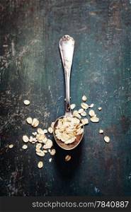 oats in a metal spoon on wooden table