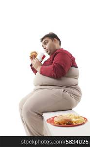 Obese man eating junk food