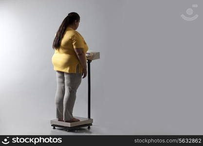 Obese woman checking her weight