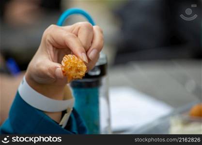 Obese woman eating dumpling. person holding sweets in hand