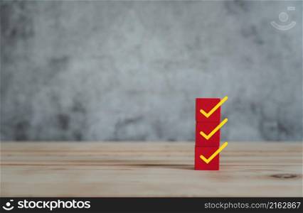Object on the table of icon sign checklist on wooden block stacking same as step stair up on the blurred grey background, Business mark up concept. copy space for text. Clipboard and check marks