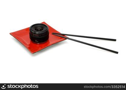 Objective lens on square oriental plate and chopsticks isolated. Objective lens on square oriental plate and chopsticks isolated