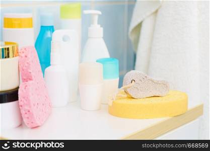 Objects, cosmetic products on the bathroom shelf. Bathing sponge in the shape of a pink heart.. Cosmetic products in bathroom
