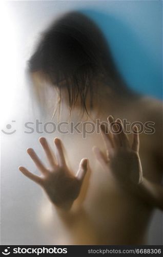 obscured naked woman behind shower door