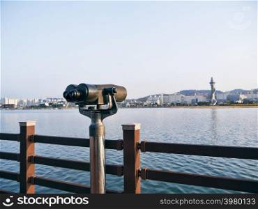Observation binoculars on the pier and Sokcho city on the background, South Korea