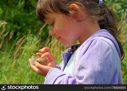 observation garden snail on children hand, watch with the utmost interes.