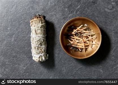 occult science and supernatural concept - white sage and cup with burnt matches. white sage and cup with burnt matches