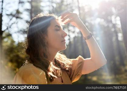 occult science and supernatural concept - young woman or witch with semiprecious crystal or gemstone performing magic ritual in forest. woman or witch performing magic ritual in forest