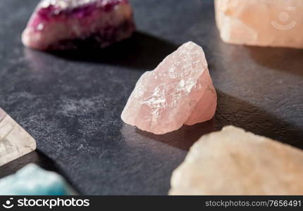 occult science, minerals and geology concept - quartz crystals and gem stones on slate background. quartz crystals and gem stones on slate background