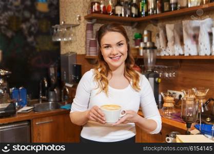 occupation, profession, drinks and people concept - happy barista woman with latte at coffee shop