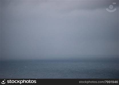 Ocean background with rain clouds. Ocean background with clouds and rain at the horizon