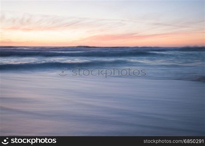 Ocean blurred waves. Stormy sunset seascape