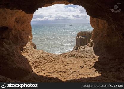 ocean cave and a boat in algarve, the south of portugal, Marinha beach