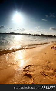 ocean footprints on sand near water