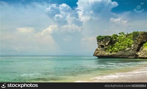 Ocean sand beach with trees on rock