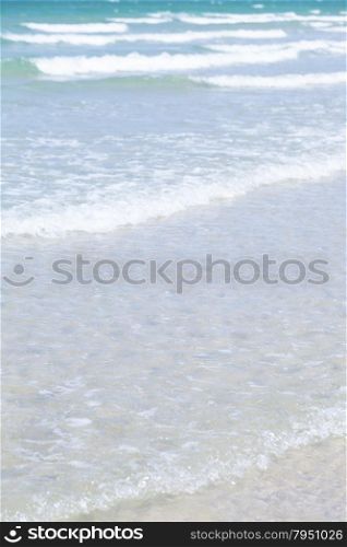 Ocean waves crashing into the beach. Waves from the sea swept shores. Crystal clear water during the daytime.