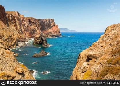 Ocean with rocky shore in sunny day, Portugal. Ocean with mountains