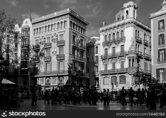 OCT 27, 2012 Bearcelona, Spain - Old Classic buildings and tourists on La Rambla street under warm beautiful sunlight in afternoon.