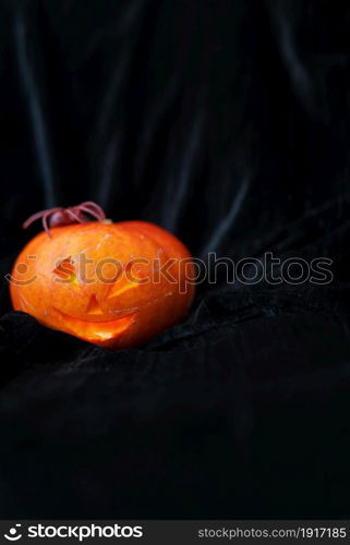 October 31, Halloween - Old Jack-o-Lantern on a black background. The spider sits on a pumpkin. Place for an inscription. October 31, Halloween - Old Jack-o-Lantern on a black background. The spider sits on a pumpkin. Place for an inscription.