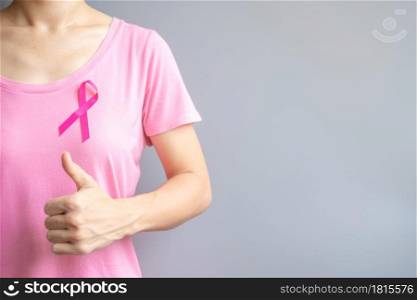 October Breast Cancer Awareness month, elderly Woman in pink T- shirt with Pink Ribbon and thumb sign for supporting people living and illness. International Women, Mother and World cancer day concept
