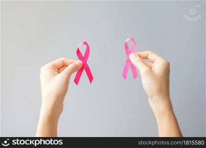 October Breast Cancer Awareness month, hand holding Pink Ribbon for supporting people living and illness. International Women, Mother and World cancer day concept