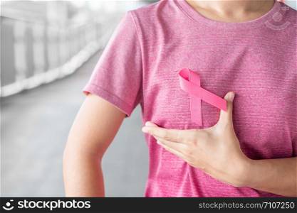 October Breast Cancer Awareness month, Woman in pink T- shirt with Pink Ribbon for supporting people living and illness. Healthcare, International women day and World cancer day concept