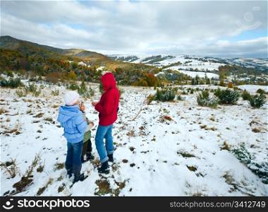 October Carpathian mountain plateau with first winter snow and autumn colorful foliage (and mother with children)