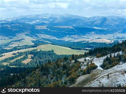 October Carpathian mountain plateau with first winter snow and autumn foliage