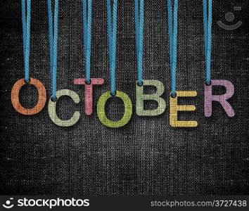 October letters hanging strings with blue sackcloth background.. October