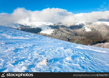 October mountain view with first winter snow and last autumn colourful foliage on far mountainside