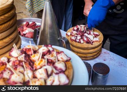 Octopus being prepared the Galician way (&rsquo;a feira&rsquo;) at a stall in a weekly market in Ourense, Spain. The octopus is traditionally boiled for hours in big brass cans on the streets on holidays and Sundays, sliced and served with salt, paprika and olive oil on wooden plates.