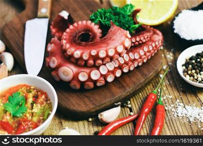 Octopus food on wooden cutting board background, cooked squid salad chili sauce seafood cuttlefish dinner restaurant, Boiled octopus tentacles