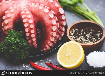 Octopus food salad vegetable with lemon chili salt coriander parsley and pepper on black plate for boiled cooked seafood, Fresh squid octopus cuttlefish dinner restaurant