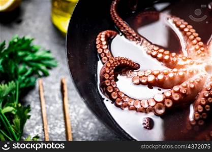 Octopus is boiled in a pot of water. On a rustic background. High quality photo. Octopus is boiled in a pot of water.