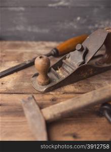 Od vintage hand tools on wooden background. Carpenter workplace. Tinted photo