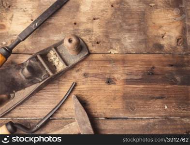 Od vintage hand tools on wooden background. Carpenter workplace. Tinted photo