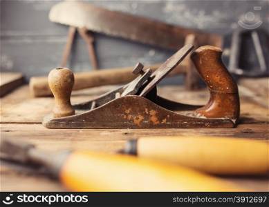 Od vintage hand tools on wooden background. Focus on jack-plane. Carpenter workplace. Tinted photo