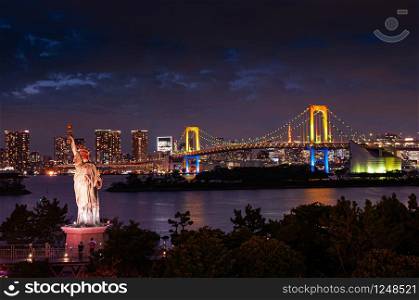 Odaiba Rainbow bridge and statue of Liberty with illuminated colourful light and Tokyo bay view at night