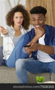offended girl sitting by boyfriend watching football match tv