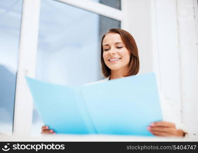 office and business concept - smiling attractive businesswoman with folder in office