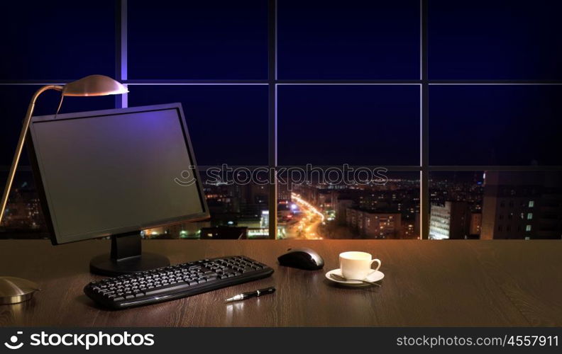 Office at night. Work place in the office at night with a city view from window