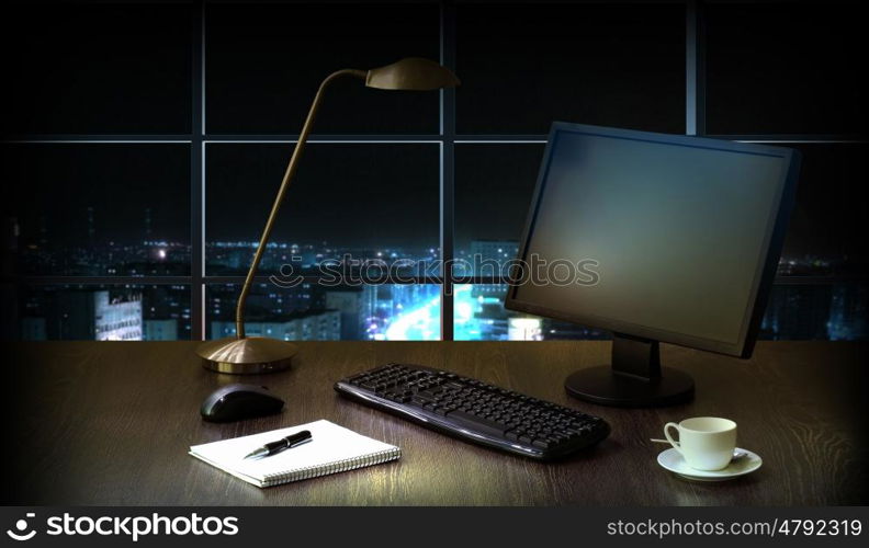 Office at night. Work place in the office at night with a city view from window