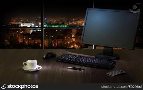 Office at night. Work place in the office at night with a city view from window