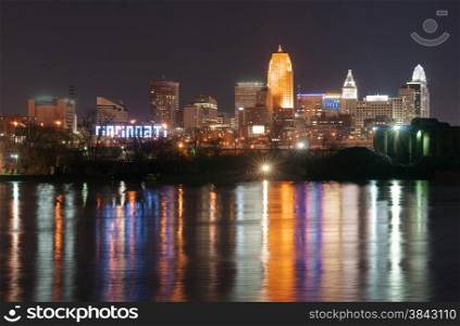 Office buildings light are reflected in the flowing river called Ohio