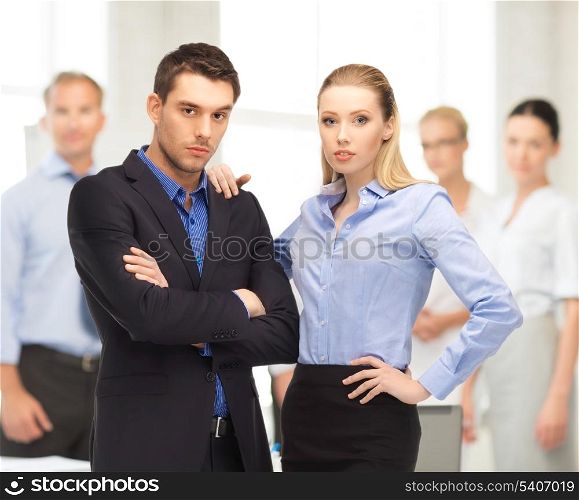 office, buisness, teamwork concept - businessman and businesswoman in the front of team