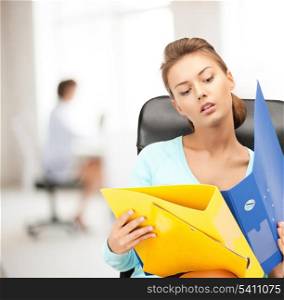 office, buisness, teamwork concept - young attractive businesswoman with folders