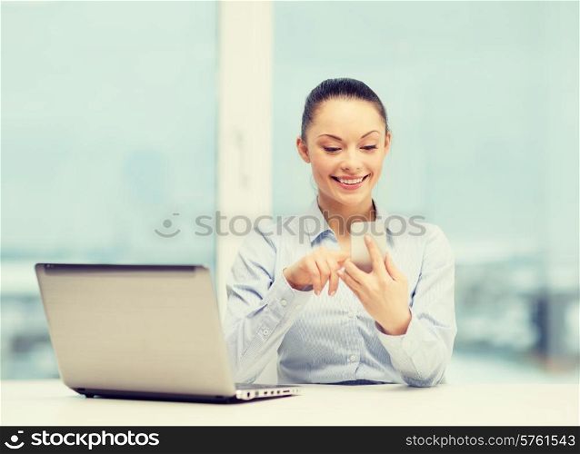 office, business and technology concept - smiling businesswoman with laptop computer and smartphone